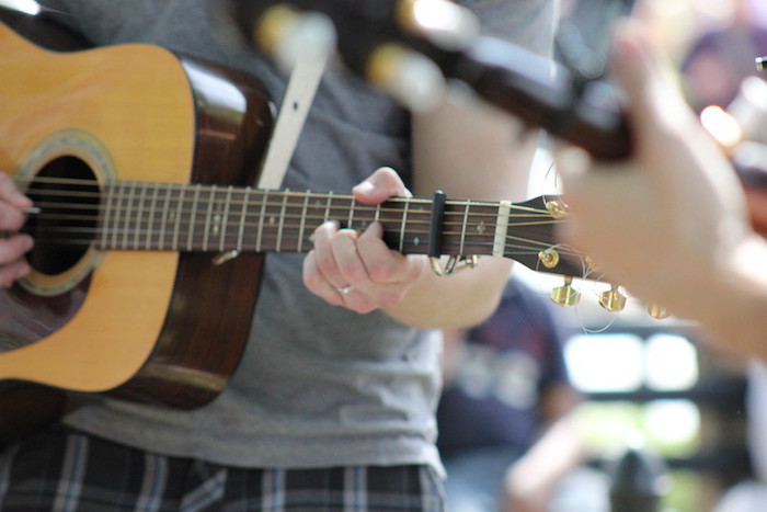 A closeup of a guitarist's hands, which can help you observe proper bluegrass jam etiquette
